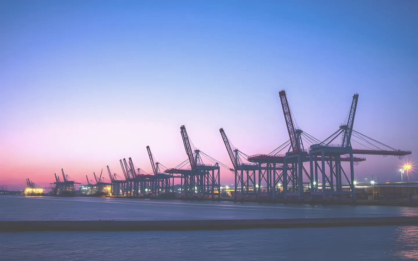 Gladstone harbour with industrial port cranes at dusk