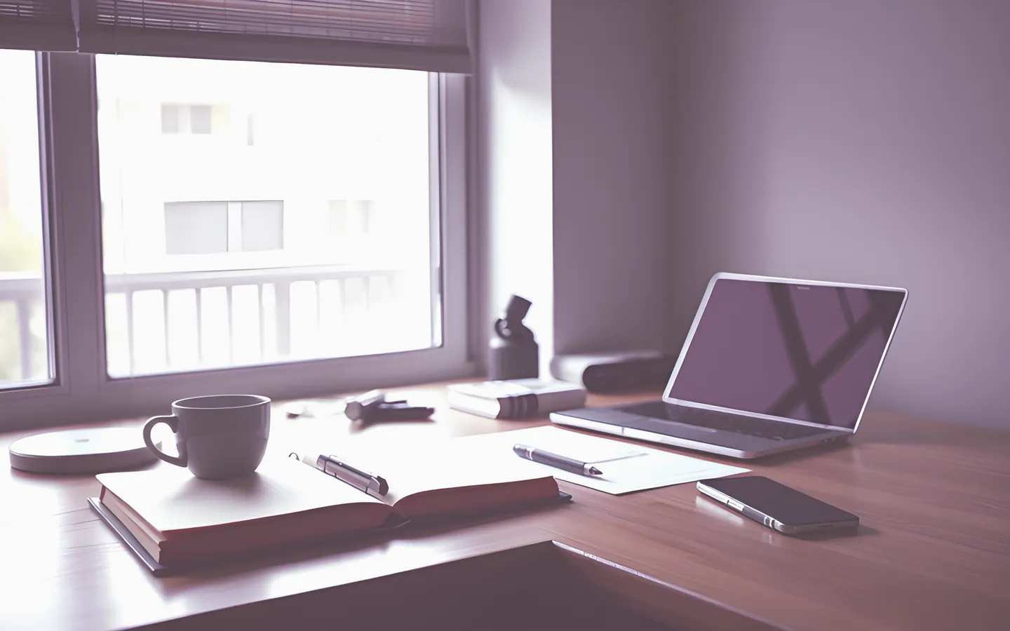 Journalist desk with notebook, laptop and coffee near a window