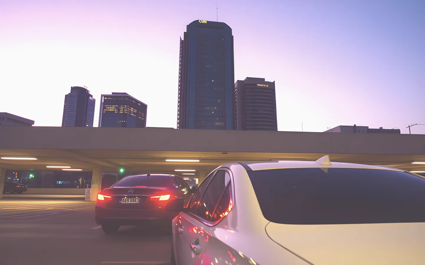 Office worker driving out of a city carpark at dusk